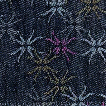 Navy denim fabric with repeating floral pattern in light blue, gold, and purple, featuring radiating lines and woven texture.